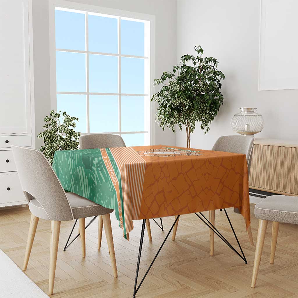 Orange and green tablecloth draped over dining table with elephant themed print