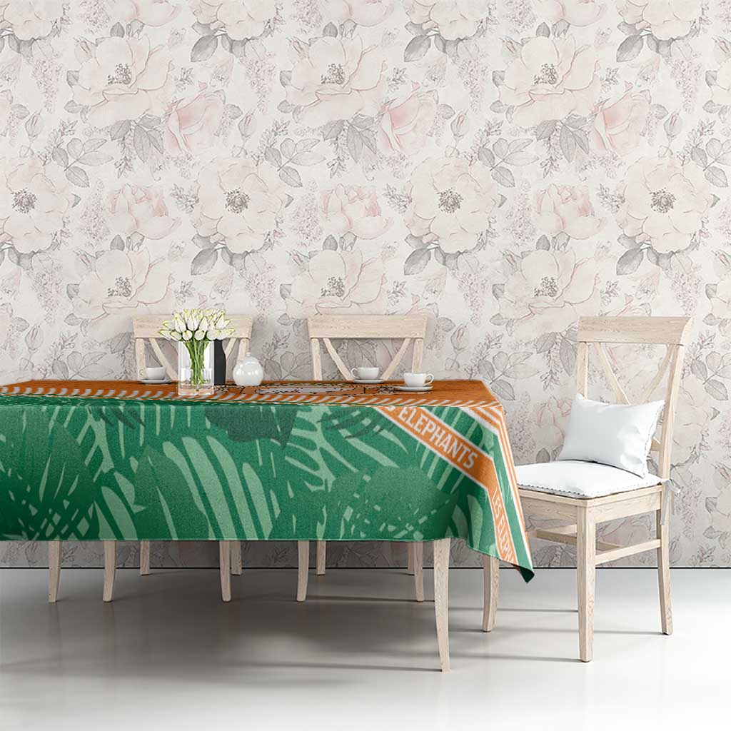 Orange and green tablecloth featuring elephant design and striped trim on dining table
