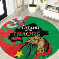 Round carpet with green, red, and black graphic design and 'I STAND WITH TRAORE' text