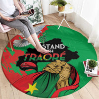 Round green carpet with I Stand With Traore graphic and raised fist design