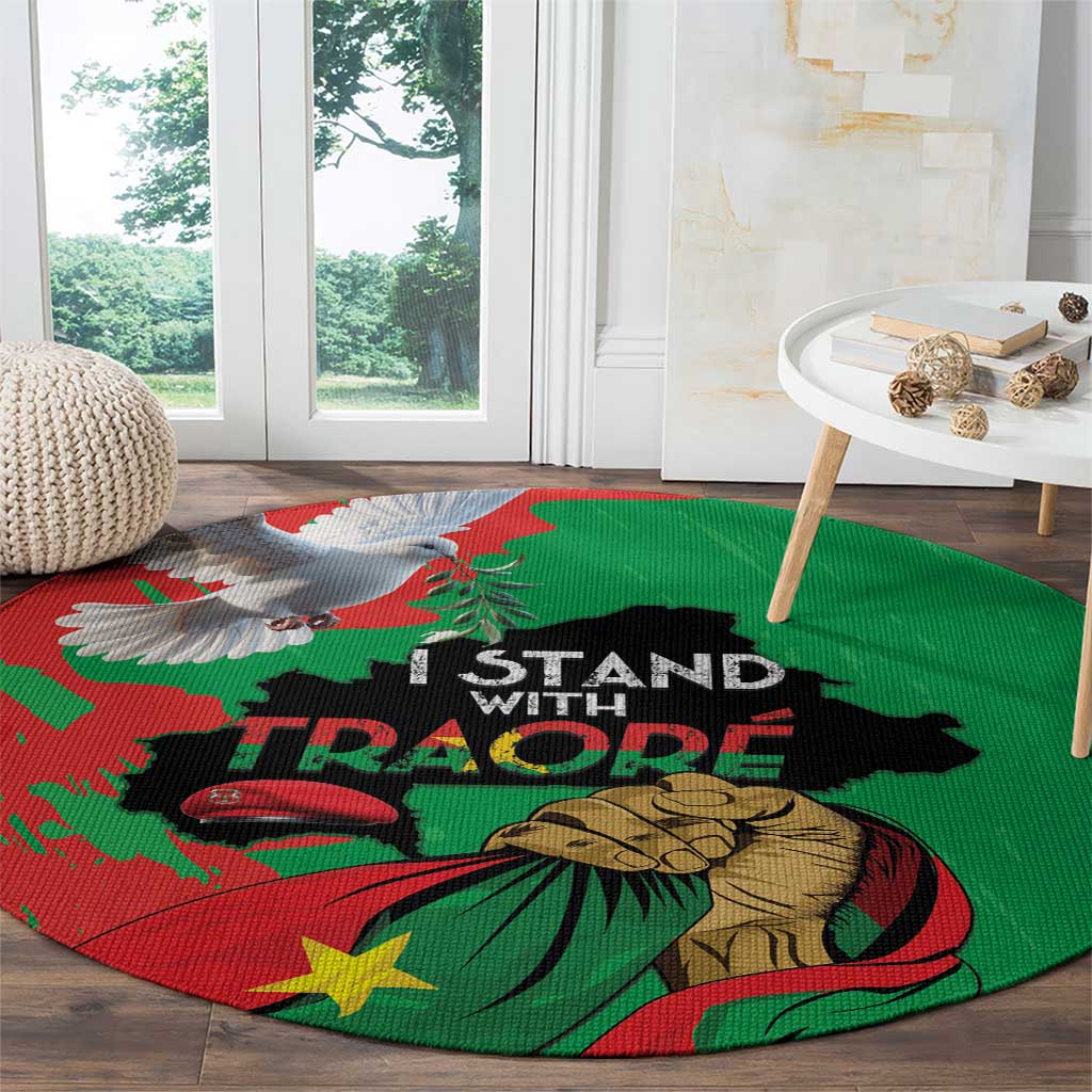 Round green carpet with Traore slogan, raised fist, birds, and flag-style graphic.