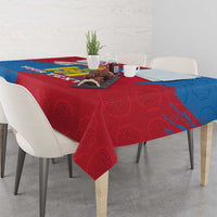 Blue and red patterned tablecloth with coat-of-arms motif, draped over a table