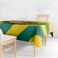 Yellow and green kente pattern tablecloth with triangular blocks, hanging over table edge