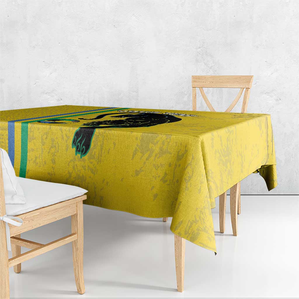 Yellow football tablecloth with black cat design and blue-green stripe, hanging over table corner
