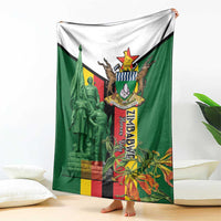 Green and white blanket featuring Zimbabwe memorial crest and Liberation War graphic
