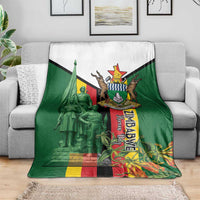 Green blanket with white top panel and large Zimbabwe memorial crest on couch