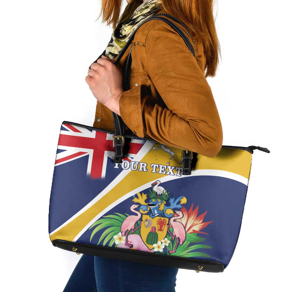 Dark blue leather tote with black top zipper, handles, and tropical coat-of-arms print