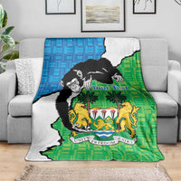 Sierra Leone blanket in green and blue with chimpanzees and coat of arms on couch