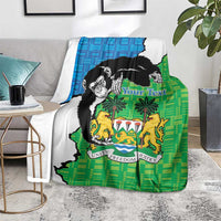 Green and blue Sierra Leone blanket with chimpanzees and coat of arms on floor