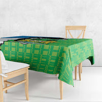 Green personalised tablecloth with geometric pattern and coat of arms design, draped over table