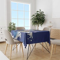 Blue patterned tablecloth with white flying fish motifs, laid over rectangular dining table