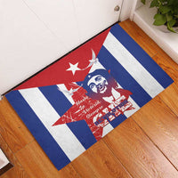 Rectangular blue rubber doormat on wood floor with Cuba stripes and Che portrait.