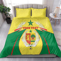 Senegal bedding set on bed: yellow and green duvet with coat-of-arms crest and 2 matching pillows