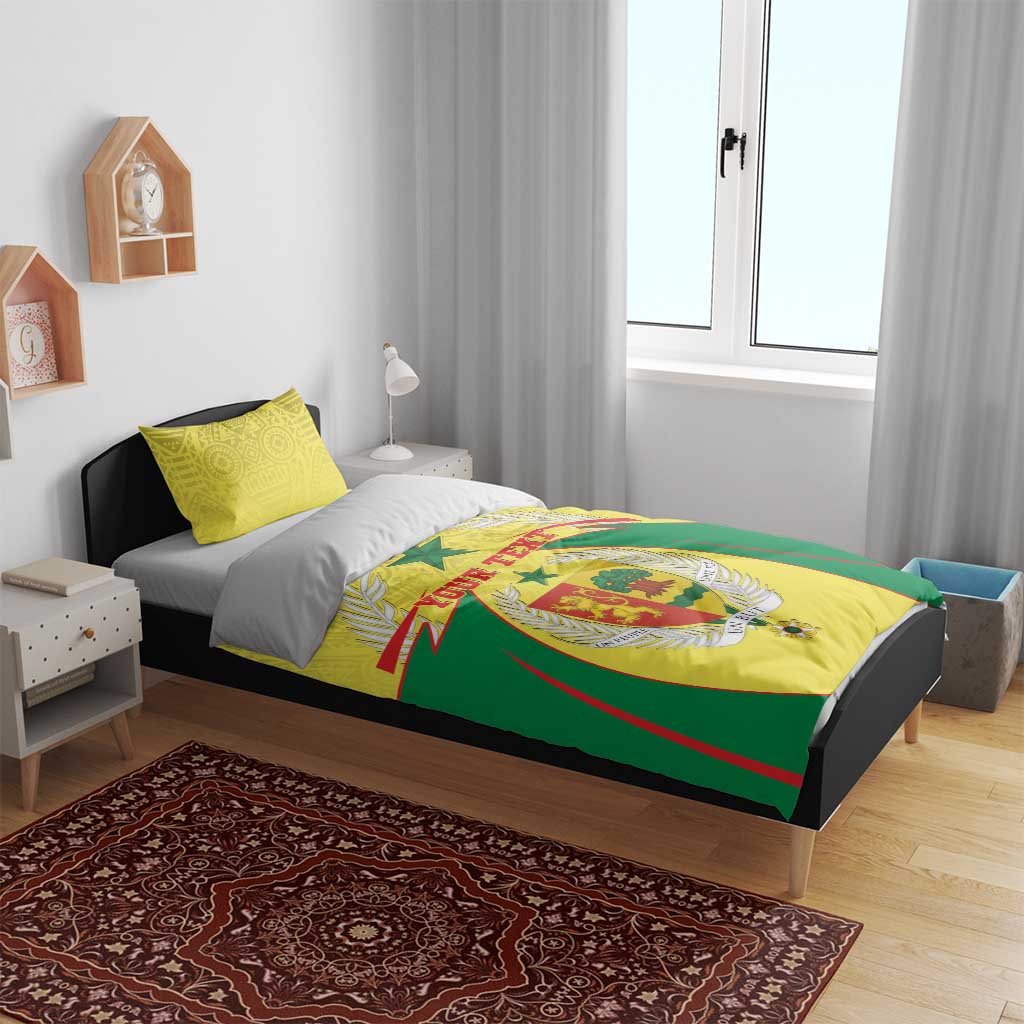 Senegal bedding set on bed: yellow and green duvet with crest design and matching yellow pillows
