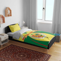 Senegal bedding set on bed: yellow and green duvet with crest design and matching yellow pillows