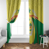 Yellow and green coat-of-arms window curtains hanging by a white-framed window