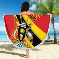 Round red beach blanket with crowned crane coat of arms and fringed white edge, held open outdoors