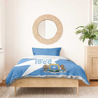 Blue and white duvet cover with Somalia crest and lions, styled on bed with pillows