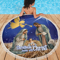 Round blue Christmas nativity beach blanket on wooden deck with white fringe edge