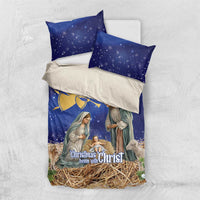 Blue Christmas bedding set laid flat: duvet and two pillowcases with nativity and angel art