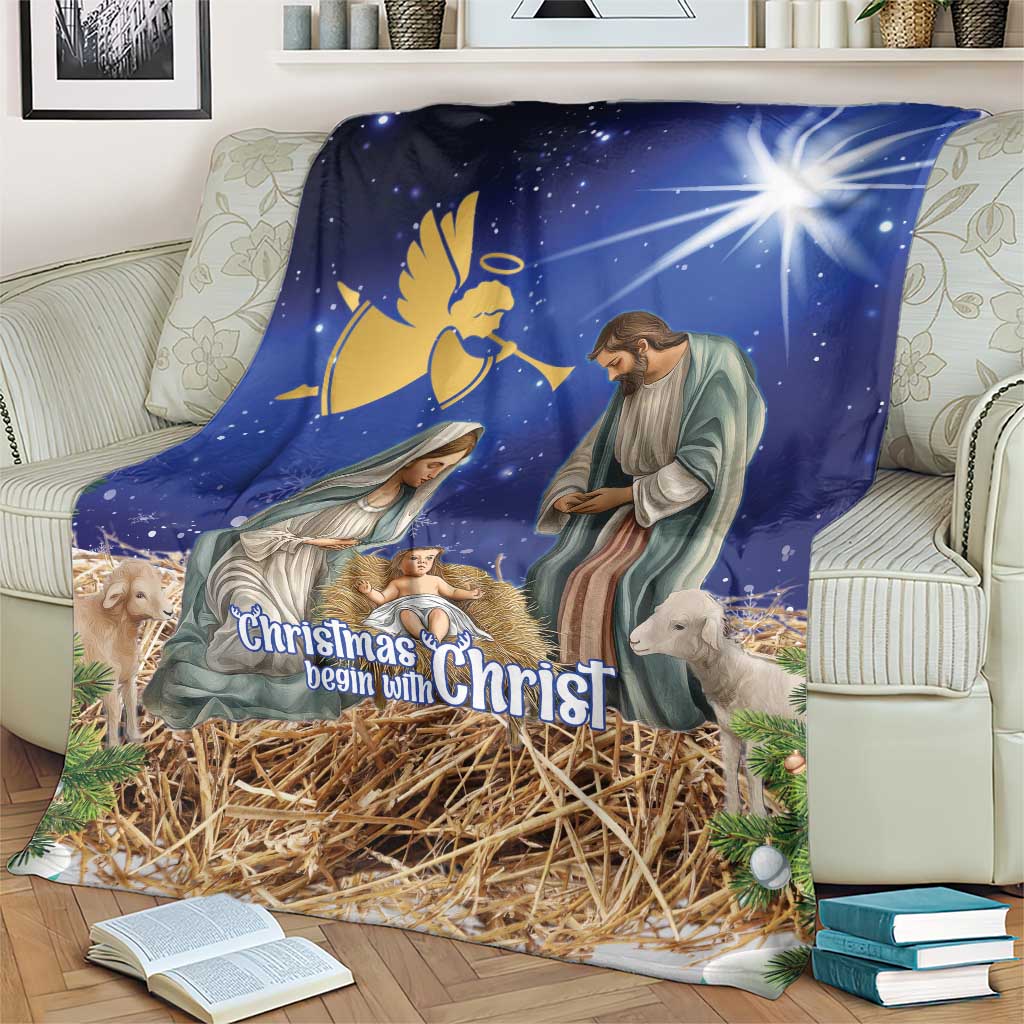 Blue Christmas blanket on couch showing nativity figures above straw manger