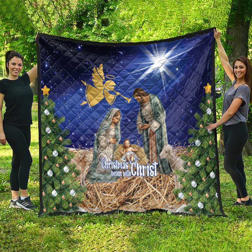 Blue Christmas quilt featuring nativity figures, angel symbol, pine and ornaments border