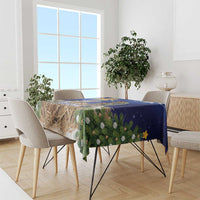 Blue Christmas tablecloth with evergreen garland and pinecone motif along table edge