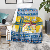 Scandinavian Christmas blanket draped over seating, blue-and-yellow festive pattern with emblem