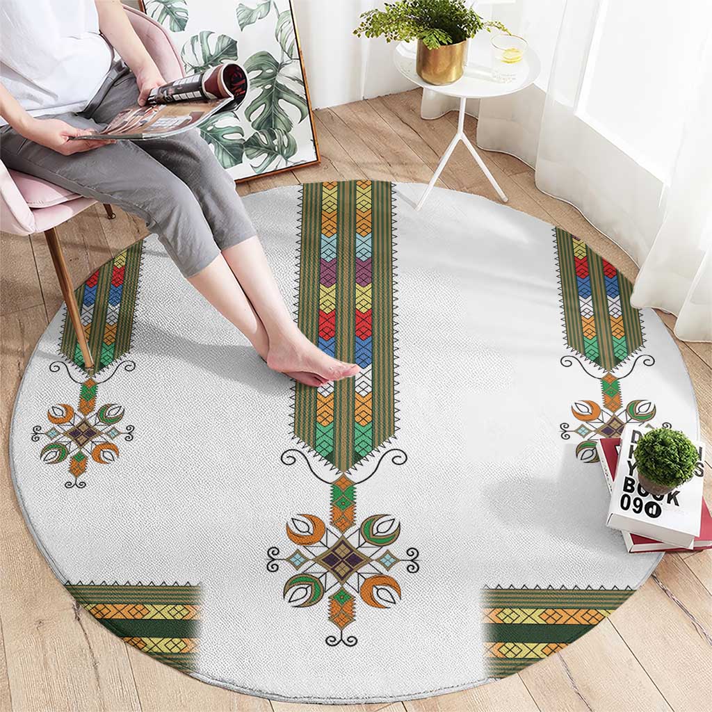 Round white area rug with central cross motif and multicolor patterned borders