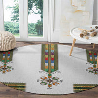 Round white rug with central vertical band and decorative floral cross in multicolor