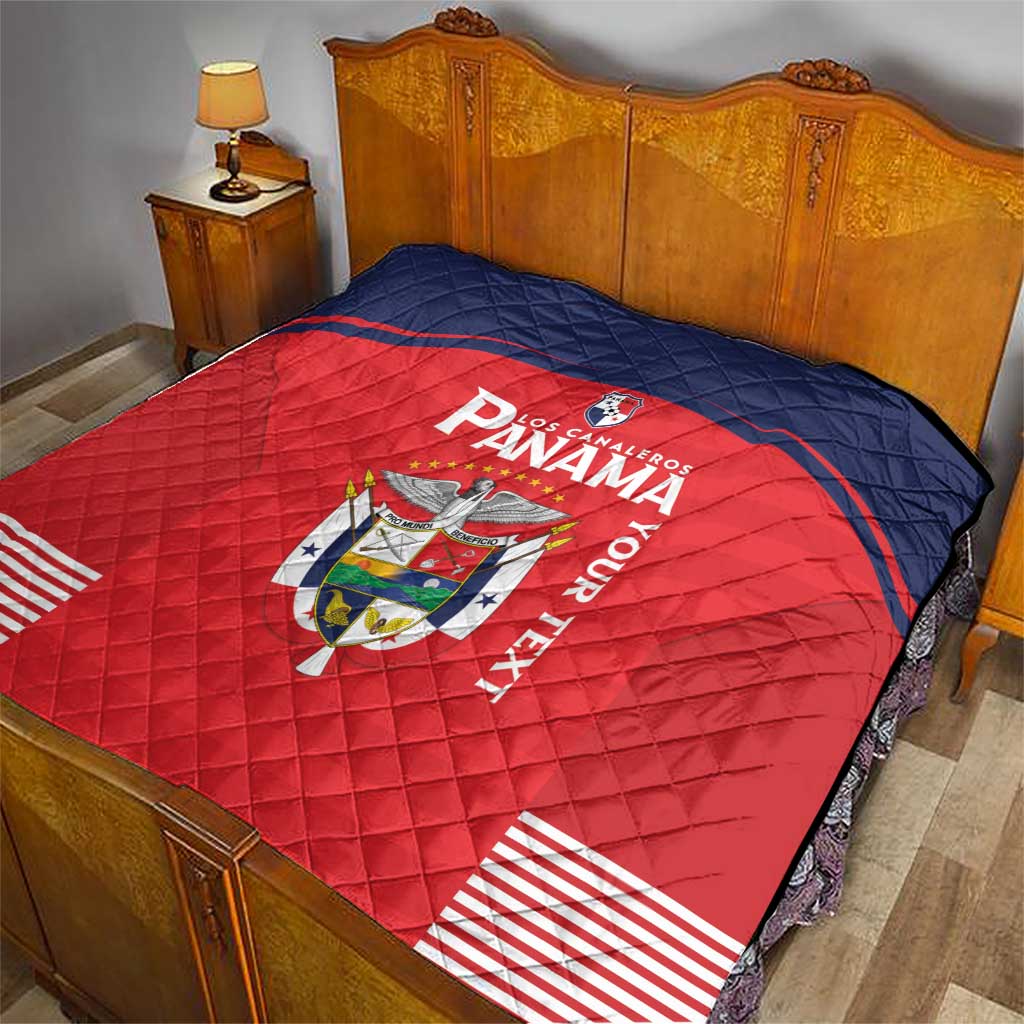 Red and navy quilt blanket on bed with Panama crest, “Panama” text, and striped hem.