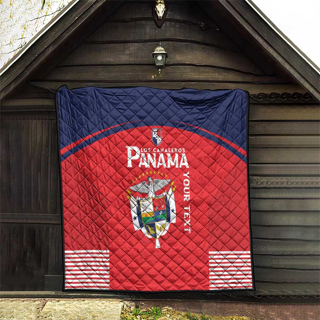 Red Panama quilt blanket hanging outdoors, showing crest logo, navy border, and stripe details.