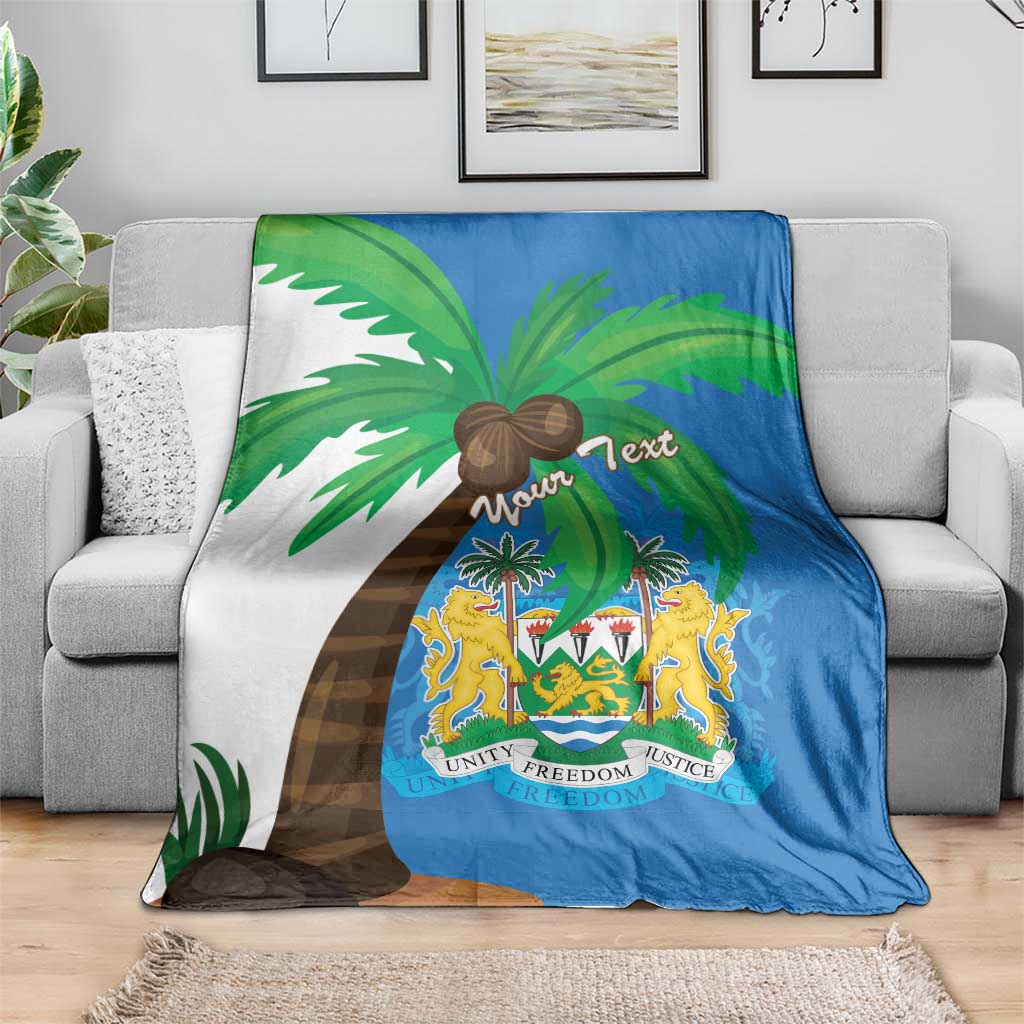 Blue Sierra Leone flag blanket coat with palm trees and crest shield, spread on couch