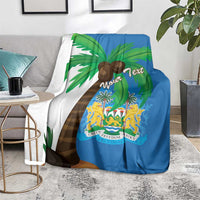 Blue blanket coat with palm leaves and crest shield graphic, draped on seating