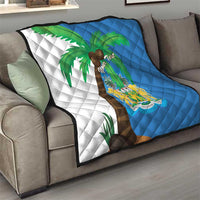 Sierra Leone quilt blanket on living room sofa, split blue/white with palm and crest