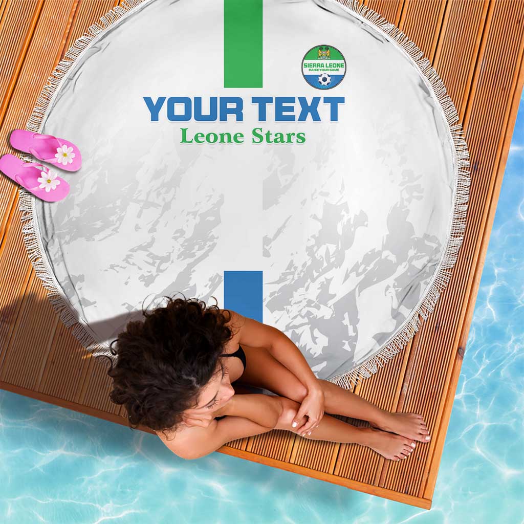 White round beach blanket with fringe, green/blue flag stripes and Leone Stars text