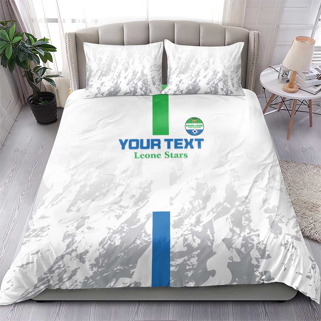 White bedding set with two pillowcases, grey silhouette pattern and blue/green central stripe