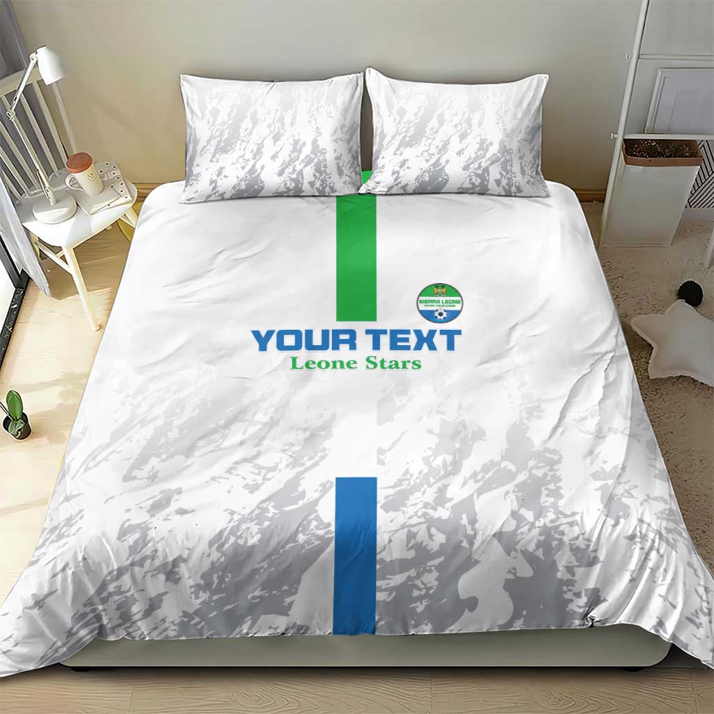 White bedding set with two pillowcases, grey silhouettes, blue/green band and crest logo