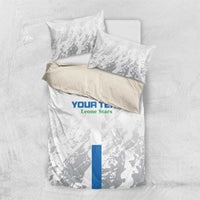 White duvet cover and two pillow shams with grey pattern and blue center stripe