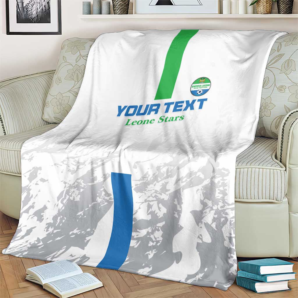 White and gray football blanket on sofa with green stripe and blue vertical panel