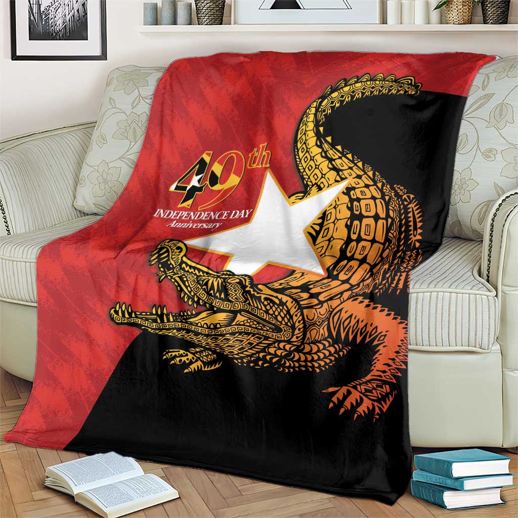East Timor Independence Day blanket draped on couch, red and black with gold crocodile art