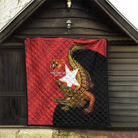 Red and black quilt hanging outdoors with quilted pattern and golden crocodile emblem, 40th text