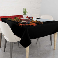 Black tablecloth with red and gold crocodile-themed centerpiece graphic, with corner drape