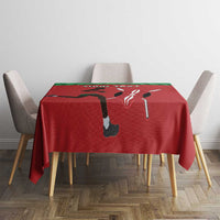 Red tablecloth on a small dining table with green top edge and sports-themed graphic