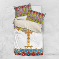 White comforter set with gold cross motif and colorful geometric tile pattern; two pillow shams.