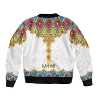 White unisex bomber jacket with large gold cross graphic and multicolor geometric pattern