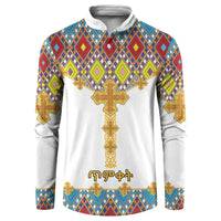 White button sweatshirt with colorful diamond pattern and large gold cross graphic