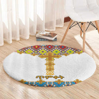 Round white carpet with a central gold cross, plus blue, green, and purple geometric tiles