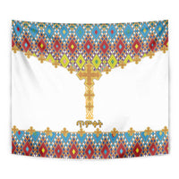 Wall tapestry close-up: multicolor diamond border framing a golden cross on white