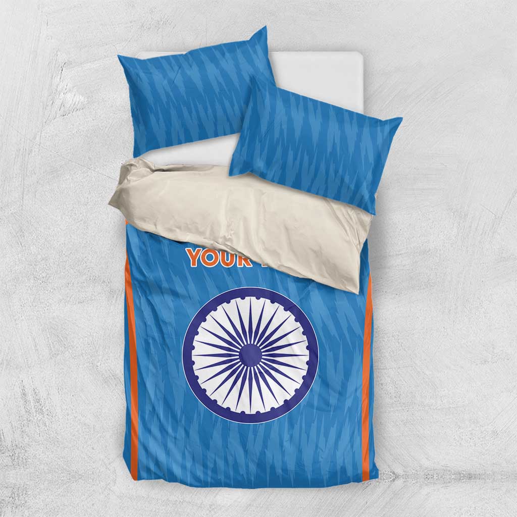 Blue duvet cover with orange stripes and circular India emblem, with two blue pillows